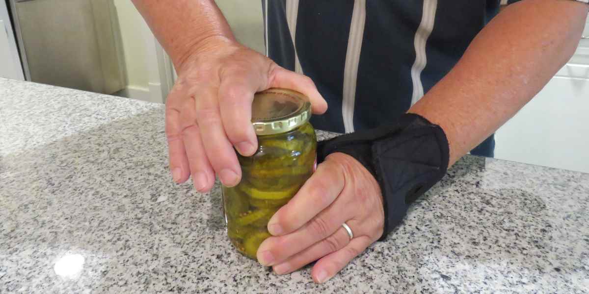 A man wearing Wrist brace trying to open the can